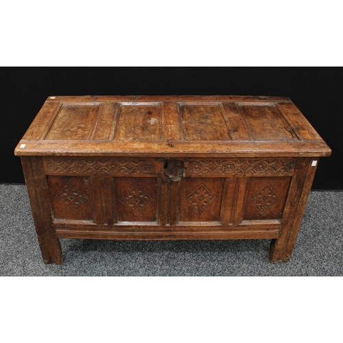 1289 - A 17th century oak blanket chest,  above a four panel front carved with lozenges, stile feet, 117cm ... 