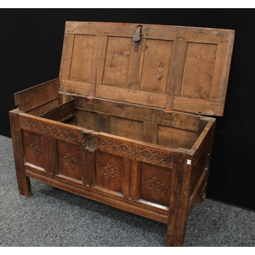 1289 - A 17th century oak blanket chest,  above a four panel front carved with lozenges, stile feet, 117cm ... 