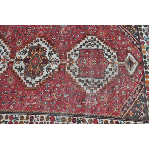 1693 - A Persian Hamandan woollen carpet, in tones of red, cream and green, 317cm x 207cm