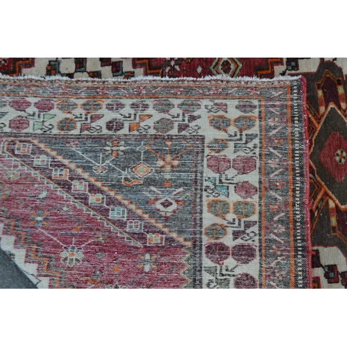 1693 - A Persian Hamandan woollen carpet, in tones of red, cream and green, 317cm x 207cm