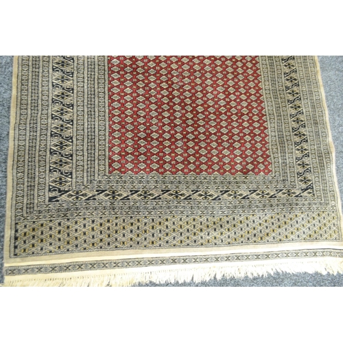 1695 - A Persian woollen rug, the field with lines of gulls in black and cream on a red ground, banded geom... 