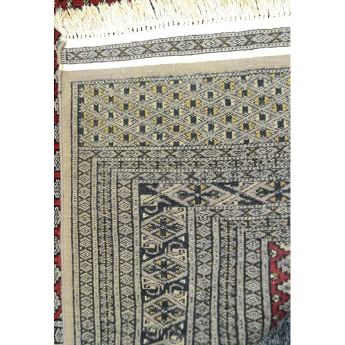 1695 - A Persian woollen rug, the field with lines of gulls in black and cream on a red ground, banded geom... 