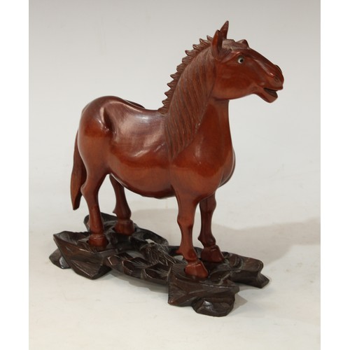 64 - A Japanese hardwood carving, of a horse, standing four square, carved and pierced stand