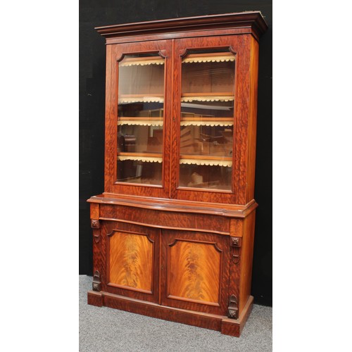 71 - A Victorian mahogany library bookcase, outswept cornice above a pair of glazed doors enclosing four ... 