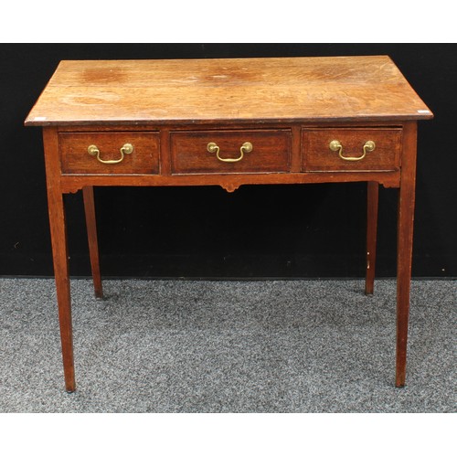 73 - A George III oak lowboy, oversailing rectangular top above three frieze drawers, brass swan neck han... 