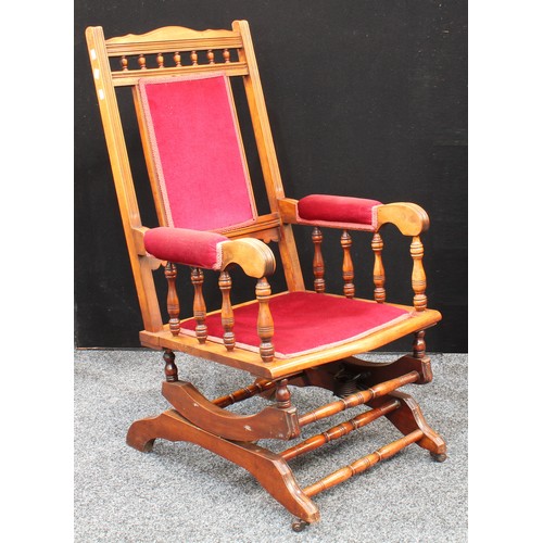 76 - An early 20th century American spring rocking chair, 107cm high