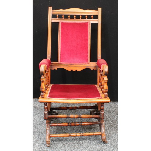 76 - An early 20th century American spring rocking chair, 107cm high