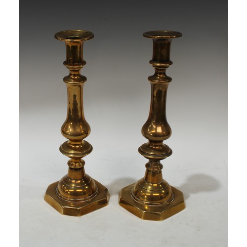 135 - A pair of 19th century brass ejector candlesticks, reel shaped sconces, canted square bases, 31cm hi... 