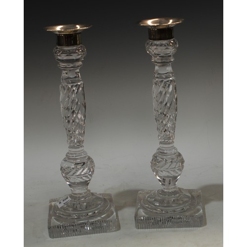 150 - A pair of glass candlesticks, with plated nozzles and sconces, wrythen columns, spreading circular b... 