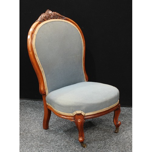 153 - A Victorian Walnut nursing chair, stuffed over upholstery,brass casters. 90cm high