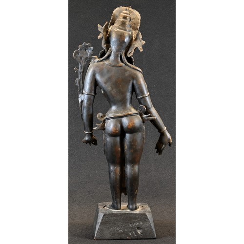 5440 - Indo-Chinese School, a dark patinated bronze, Tara, she stands, holding a ltus 'ruyi', 39cm high, eb... 