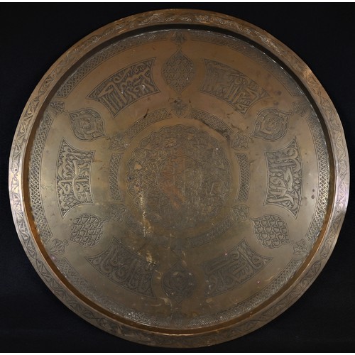 5186 - A Middle Eastern table, the circular brass top chased in the Islamic taste with calligraphy and intr... 