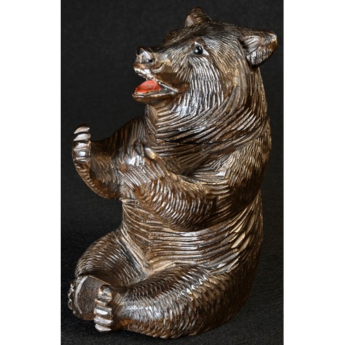 5081 - A Black Forest novelty inkwell, carved as a bear, seated, smiling, glass eyes, painted mouth, hinged... 