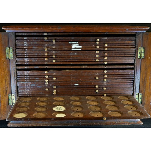 5272 - A Victorian coin collector's cabinet, oversailing top above a pair of panelled doors enclosing slidi... 