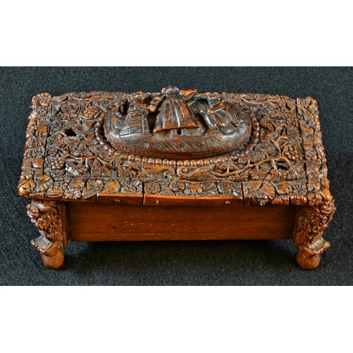 5319 - An early 19th century coquilla nut casket, hinged cover with an oval panel carved in relief with fig... 