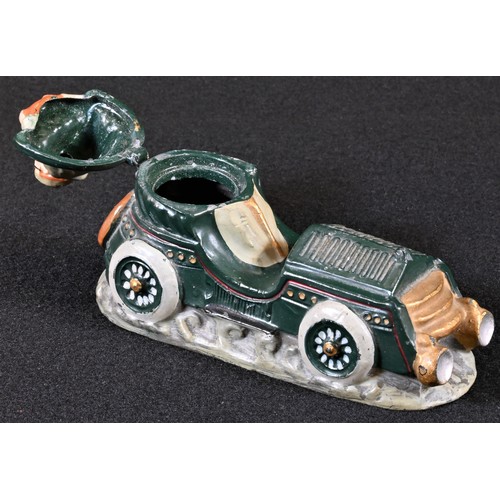 5330 - An early 20th century diecast novelty inkwell, cast as a gentleman driving a vintage motor car, hing... 