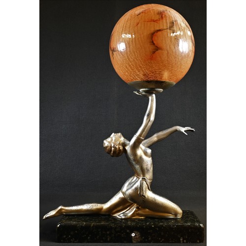 5308 - An Art Deco design silvered metal figural table lamp, as a scantily clad dancer balancing a ball, gl... 