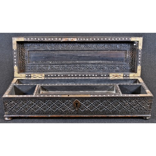 5709 - An Indian hardwood scribe’s pen box, profusely carved in shallow relief with flower heads, dense fol... 