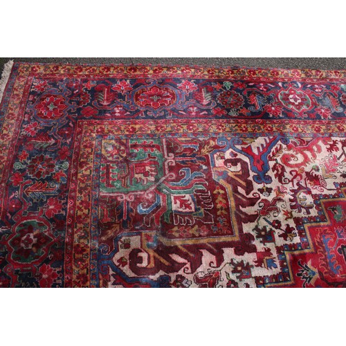 1824 - A large rectangular woollen carpet, colourfully worked in the typical Middle Eastern manner with hoo... 