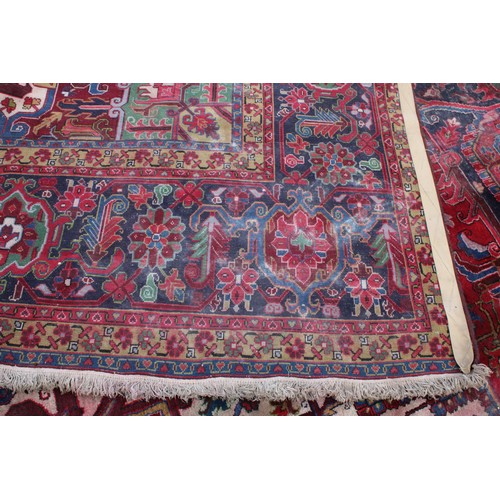 1824 - A large rectangular woollen carpet, colourfully worked in the typical Middle Eastern manner with hoo... 