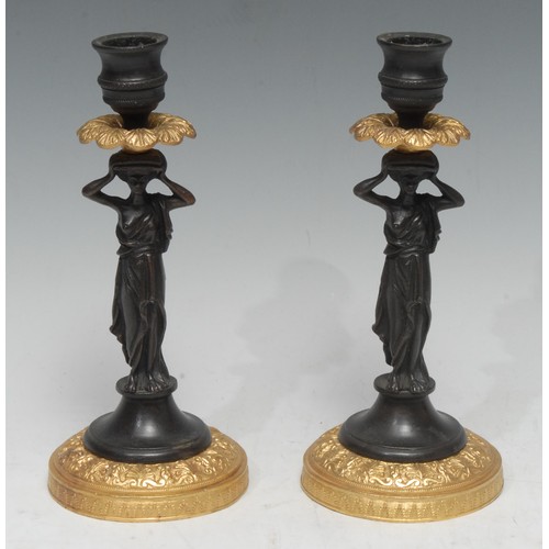 1513 - A pair of bronze and gilt metal figural candlesticks, everted leafy drip pans, classical lady column... 