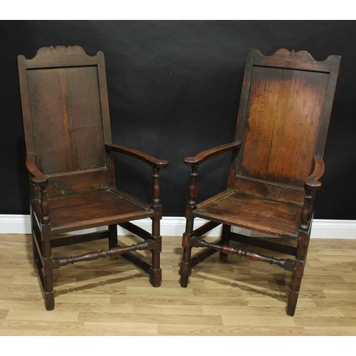 1502 - A near pair of 18th century oak Wainscot armchairs, shaped crestings, scroll arms, turned and blocke... 