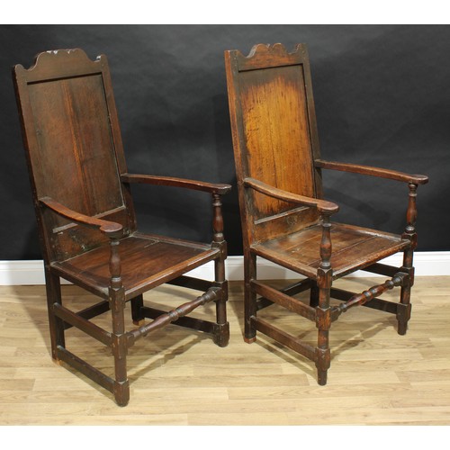 1502 - A near pair of 18th century oak Wainscot armchairs, shaped crestings, scroll arms, turned and blocke... 