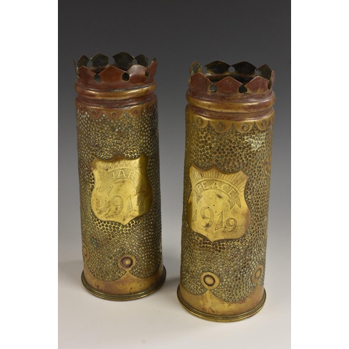 3084 - Trench Art - a pair of World War I brass artillery shells, shaped crenellated crestings, each chased... 