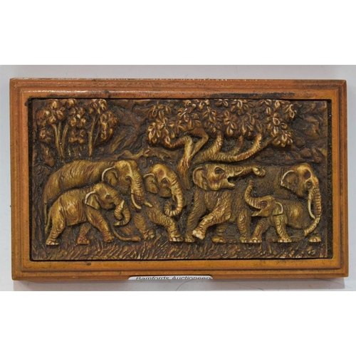 23 - A composition desk weight, in relief with a group of elephants, 15.5cm wide