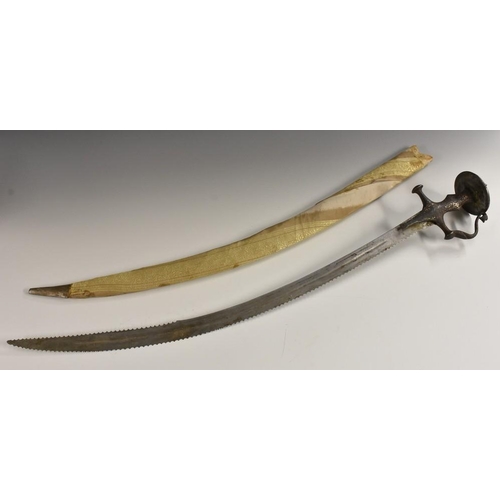 3259 - An Indian tulwar, 74.5cm curved serrated blade, the iron knuckle-bow hilt with traces of silvered de... 