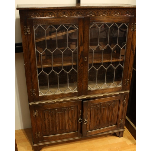 447 - A Jaycee furniture oak side cabinet, rectangular top above a pair of glazed doors enclosing two shel... 