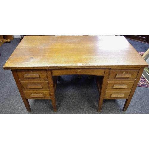 462 - A 1950's oak desk, long drawer over kneehole flanked by slides and drawers