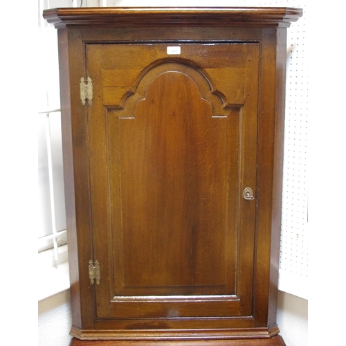 469 - An oak wall mounted corner cupboard, ogee cornice, fielded panel door, canted angles