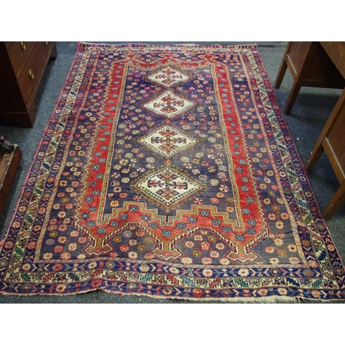 472 - A hand woven Middle Eastern rug, geometric designs in taupe, cream and cobalt on a red ground