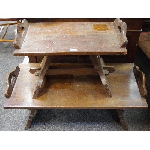 493 - An oak coffee table , rectangular top with shaped handles, spreading shaped end supports; a conformi... 