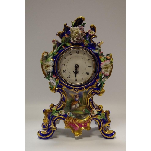 51 - A porcelain mantel clock profusely decorated with colourful flora on cobalt ground.