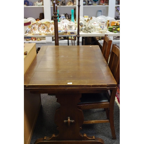 518 - An oak draw leaf dining table; two oak Arts & Crafts dining chairs; two standard lamps (5)