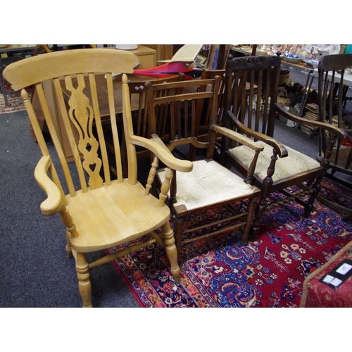 519 - A modern beech lath back carver chair; an elm carver chair with raffia seat; an oak carver (3)