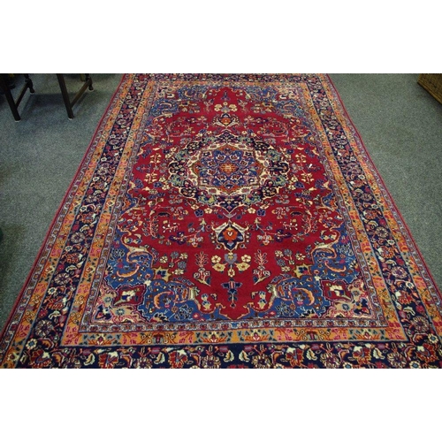 522 - A hand woven carpet, central medallion, floral designs in hues of steel blue, terracotta and cream o... 