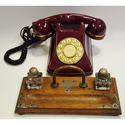 135 - A 19th century oak standish with two inkwells, c.1910;  a maroon retro-dial telephone (2)