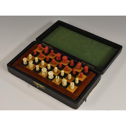 3420 - An early 20th century travelling chess set, turned pieces, folding board, 16.5cm wide, associated ca... 