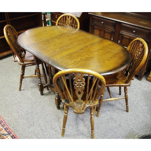 423 - A modern oak drop leaf; a set of four elm wheel back dining chairs (5)