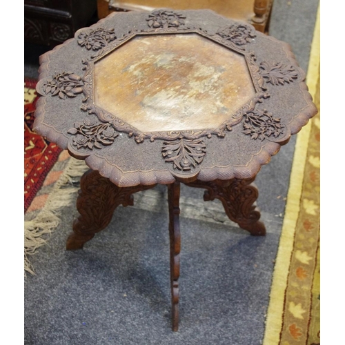 446 - An early 20th century Burmese type shaped octagonal occasional table, profusely carved throughout, s... 