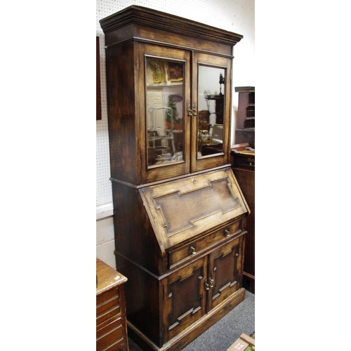 452 - A Jacobean revival bookcase, two glazed doors, enclosing shelving to top, fall front over long drawe... 