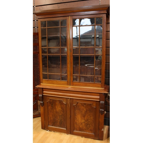 493 - A Victorian mahogany library bookcase, outswept cornice above a pair of glazed doors enclosing two s... 