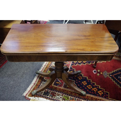 504 - A Regency mahogany pedestal tea table, outswept fluted legs terminating in lion paw feet,brass casto... 