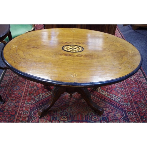 516 - A Victorian loo table, oval inlaid top, four turned columns and four carved legs to base