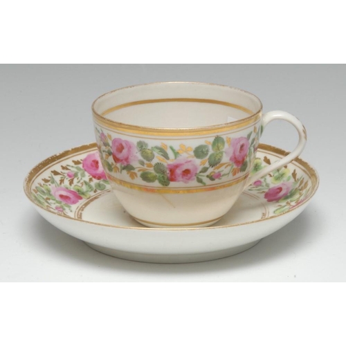 102 - A Pinxton Bute-shaped teacup and saucer, painted with pink roses, green leaves and gilt foliage, gil... 