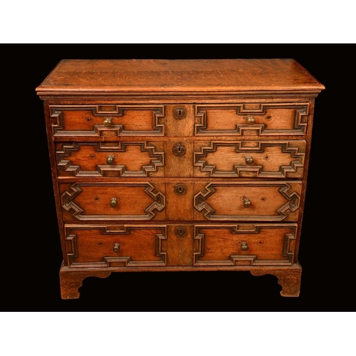 1478 - An 18th century oak block front chest, moulded top above four long graduated drawers applied with ge... 