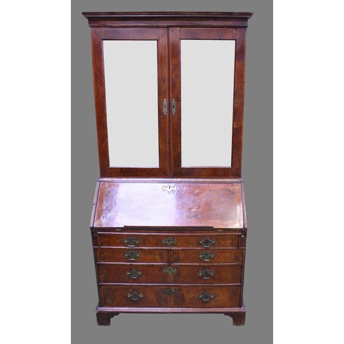 1483 - A George I/early George II walnut bureau cabinet, moulded cornice above a pair of mirrored doors, th... 